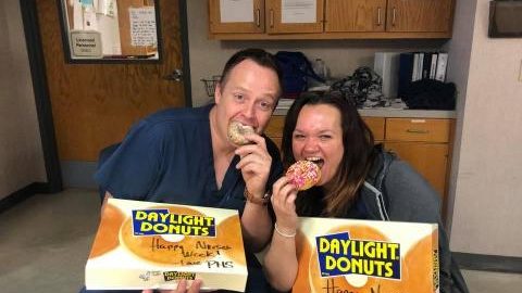 Two happy nurses eating donuts